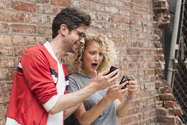 Couple sharing messages on cell phones.