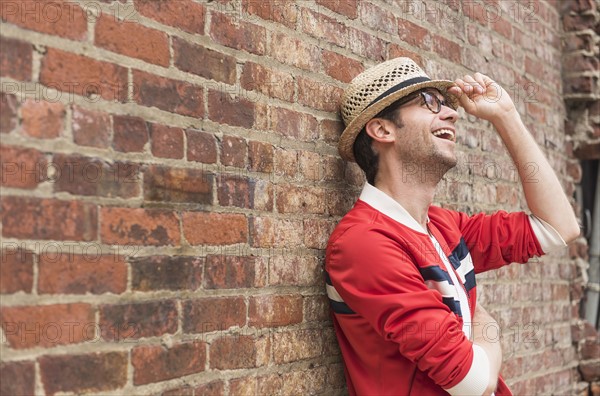 Portrait of mid adult man in front of brick wall.