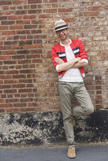 Portrait of mid adult man in front of brick wall.