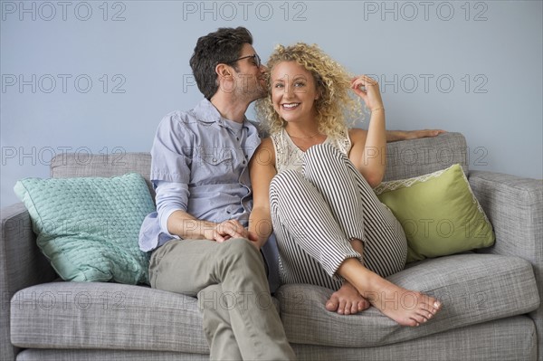 Couple sitting on sofa.