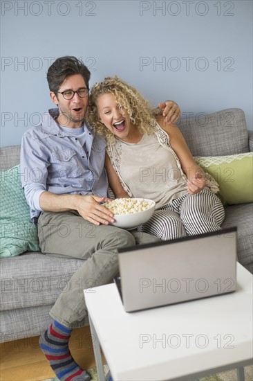 Couple watching movies on laptop.