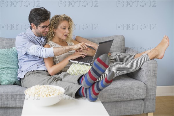 Couple watching movies on laptop.