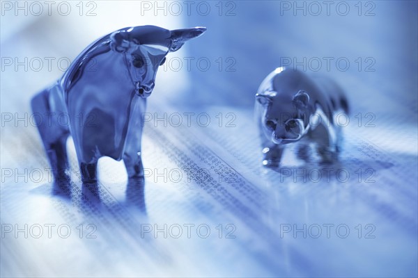 Digital composite with ceramic animals and financial newspaper.