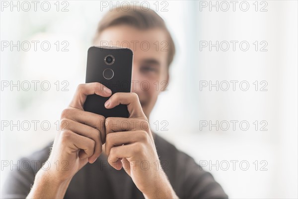 Close-up of man using mobile phone.