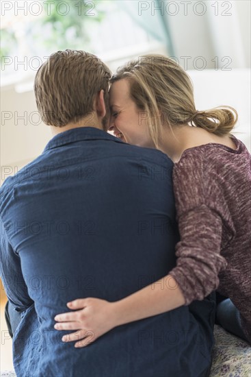 Rear view of young couple hugging.