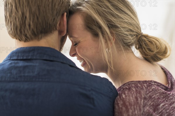 Close-up of smiling woman leaning on man.