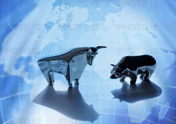 Close up of figurines of bull and bear on world map.
