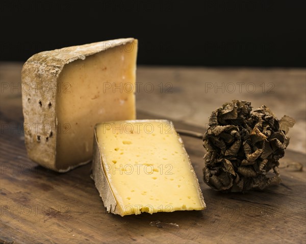 Hard cheese slices and truffle on wooden table, studio shot.