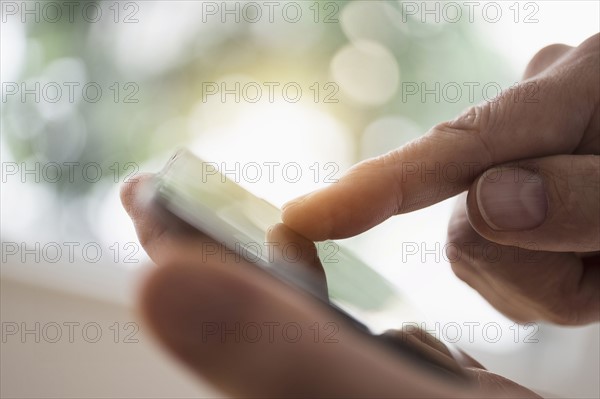 Close up of man's hand using smartphone.