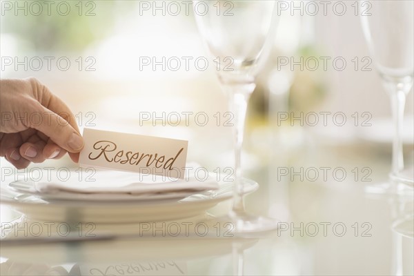 Close up of man's hand setting place in restaurant.