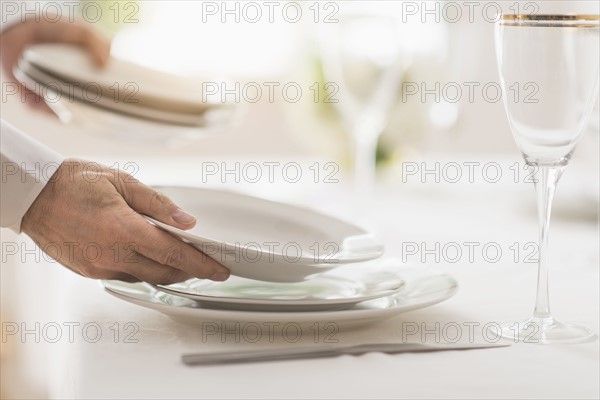 Close up of man's hand setting place in restaurant.