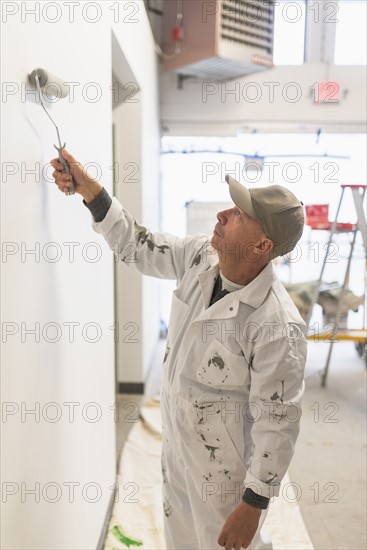 Manual worker painting wall.