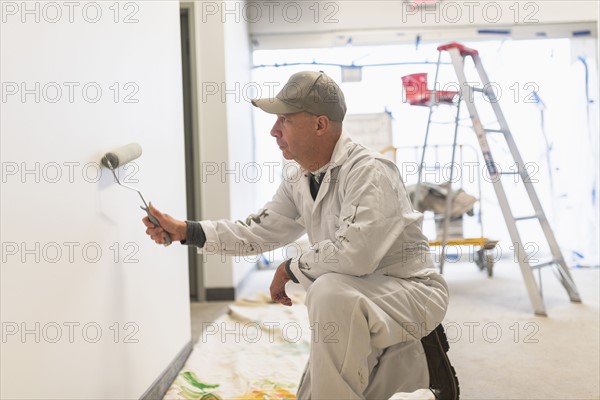 Manual worker painting wall.