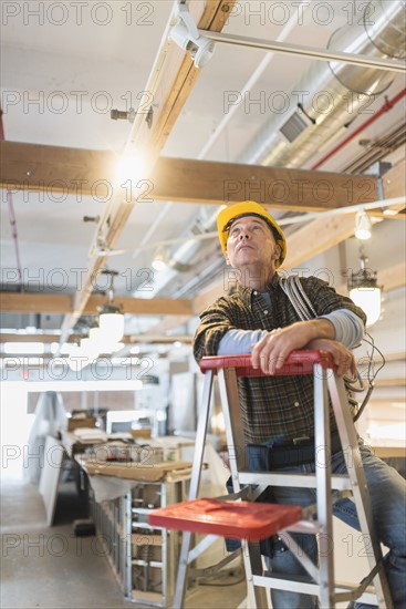 Electrician standing on step ladder.