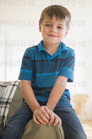 Portrait of boy (6-7) sitting on sofa