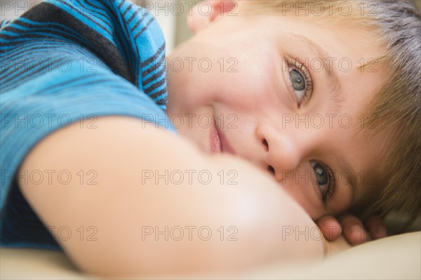 Boy (6-7) relaxing on sofa