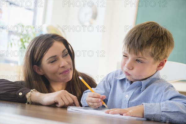 Female teacher and schoolboy (6-7) in classroom