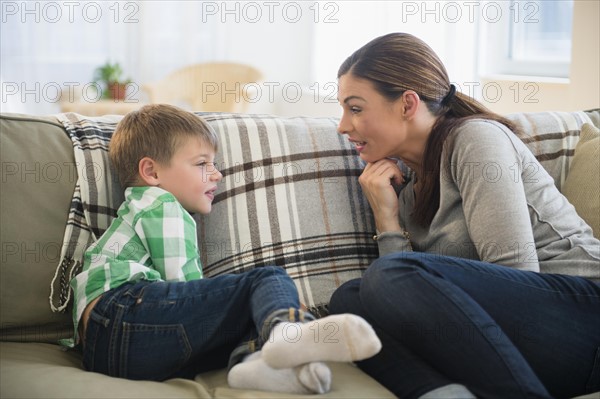 Mother and son (6-7) sitting on sofa