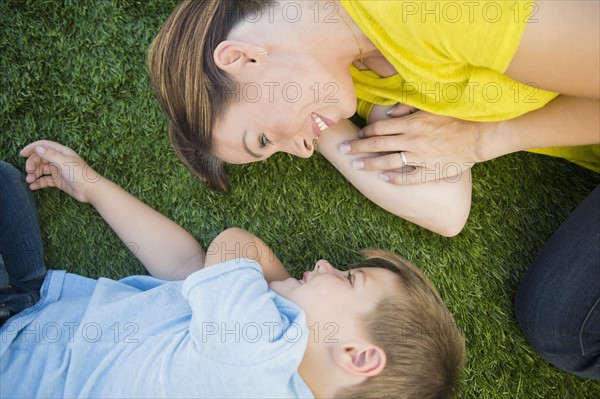 Mother and son (6-7) relaxing on grass
