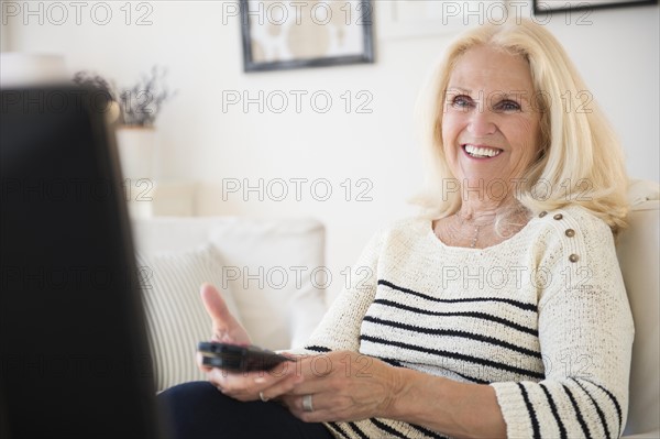 Senior woman holding remote control