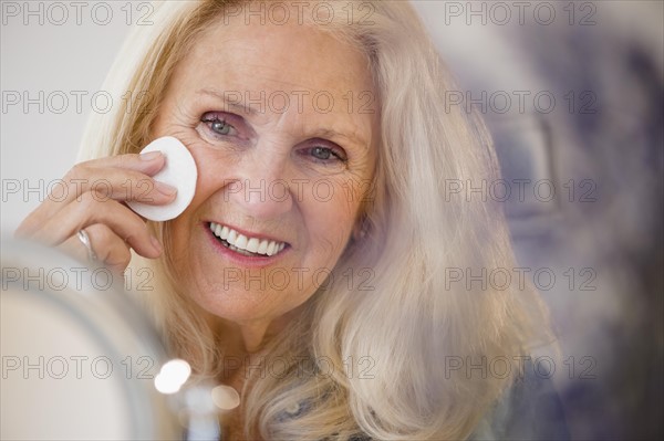 Senior woman using cotton wool pad