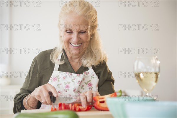 Senior woman cutting pepper