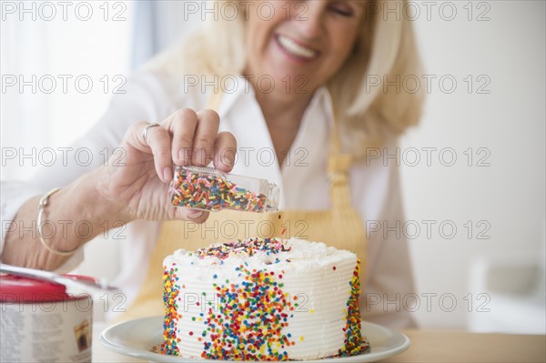 Senior woman decorating cake