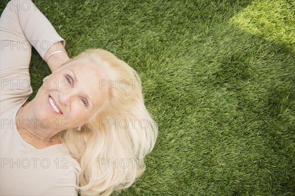 Senior woman lying on grass