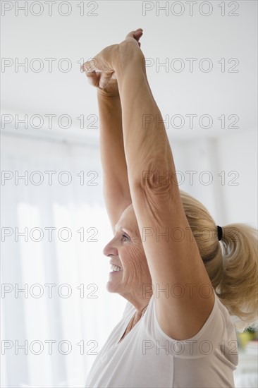 Senior woman with arms raised