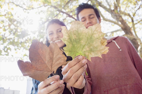 Portrait of young couple showing leaves