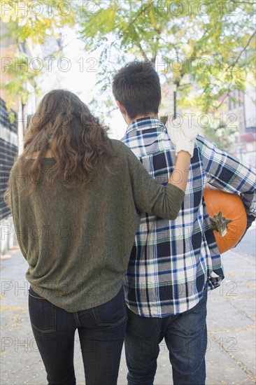 Rear view of young couple on sidewalk