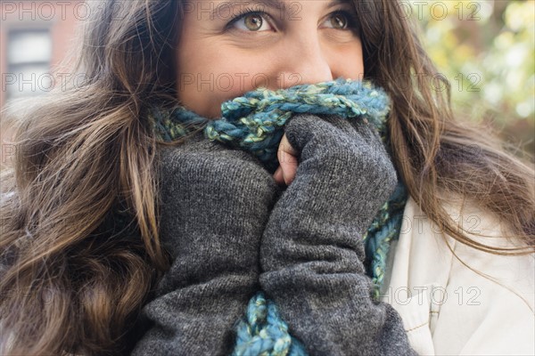 Young woman hiding her face behind scarf