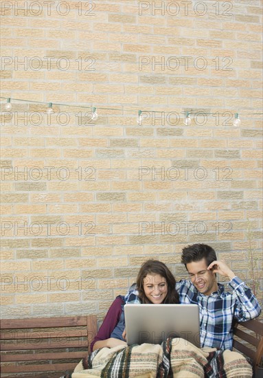 Young couple using laptop on roof