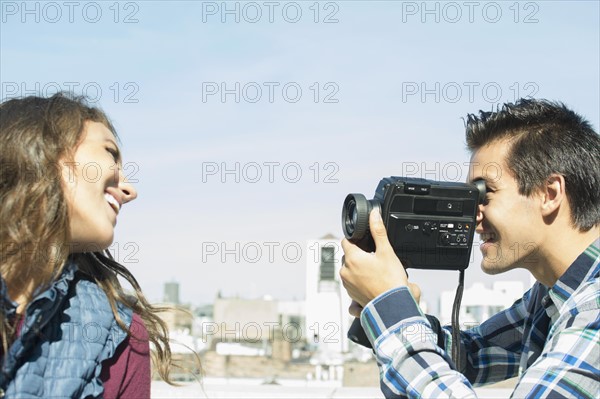 Man filming his girlfriend on roof