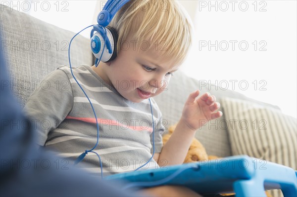 Boy (2-3) watching movies on his tablet