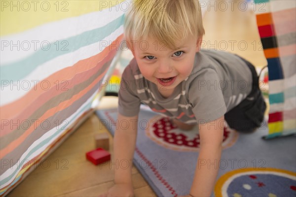 Portrait of boy (2-3) crawling in tent