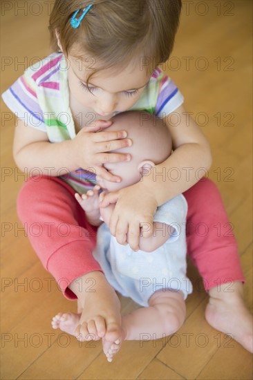 Girl (2-3) hugging her doll