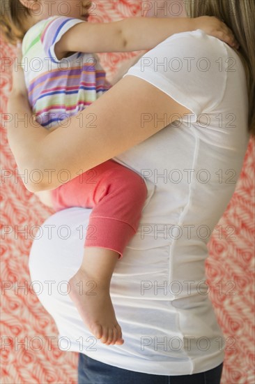 Side-view of pregnant woman with daughter (2-3)