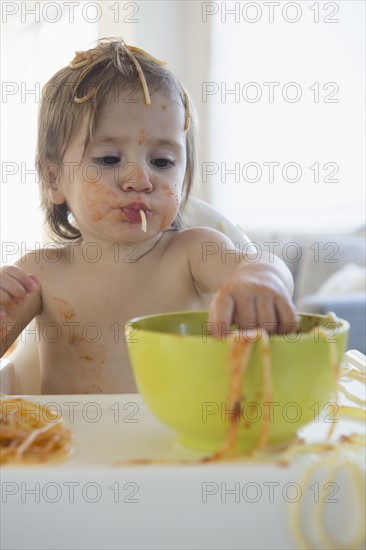 Girl (2-3) eating spaghetti