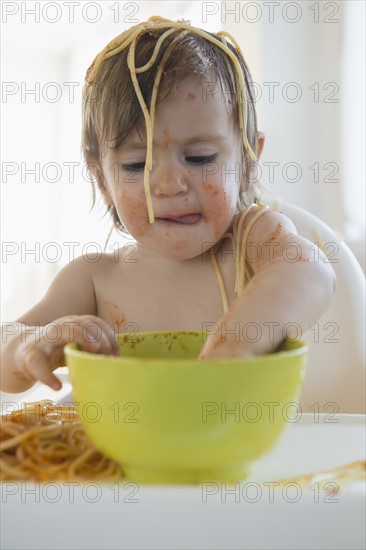 Girl (2-3) eating spaghetti