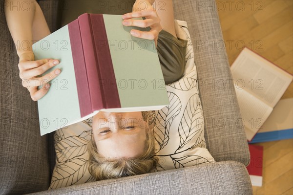 Woman reading book on sofa