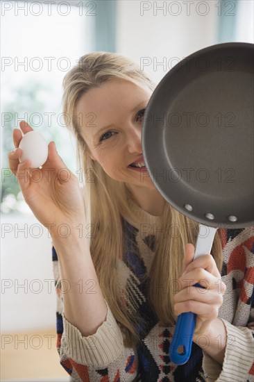 Woman holding frying pan and egg