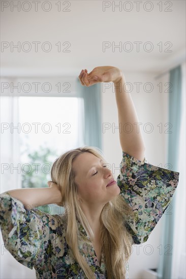 Blond woman stretching at home