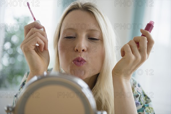 Woman applying lipgloss