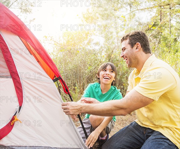 Father and son (12-13) setting up tent