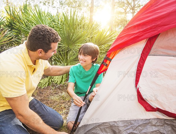 Father and son (12-13) setting up tent