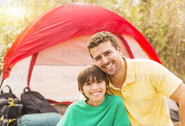 Portrait of father and son (12-13) camping