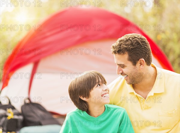 Portrait of father and son (12-13) camping