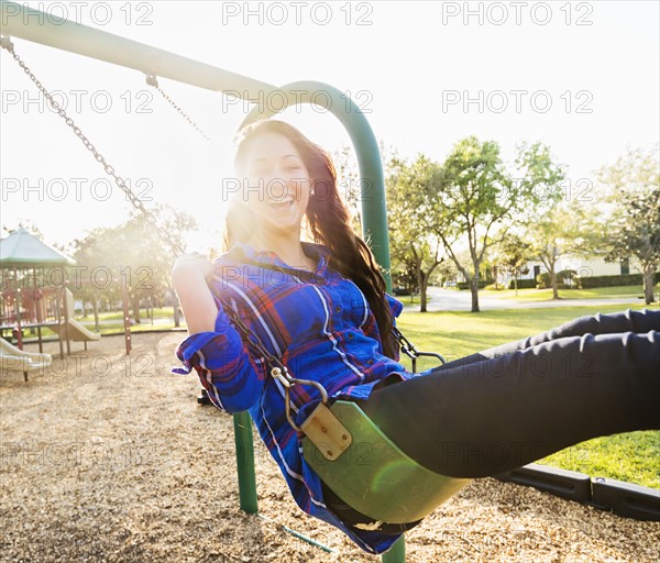 Woman swinging in playground