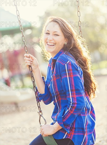 Woman swinging in playground